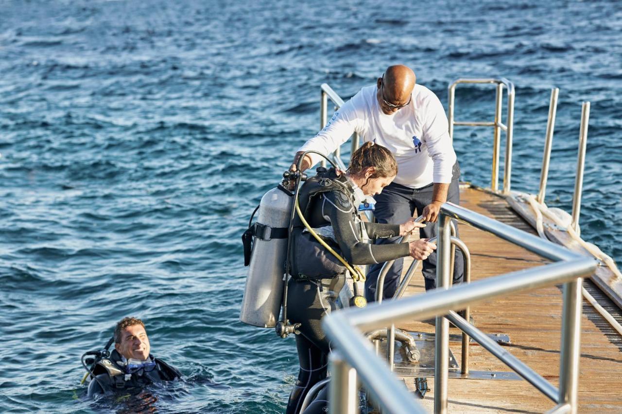Four Seasons Resort Sharm El Sheikh Exterior foto A stage-equipped diver being helped into the water by a stage-bearer